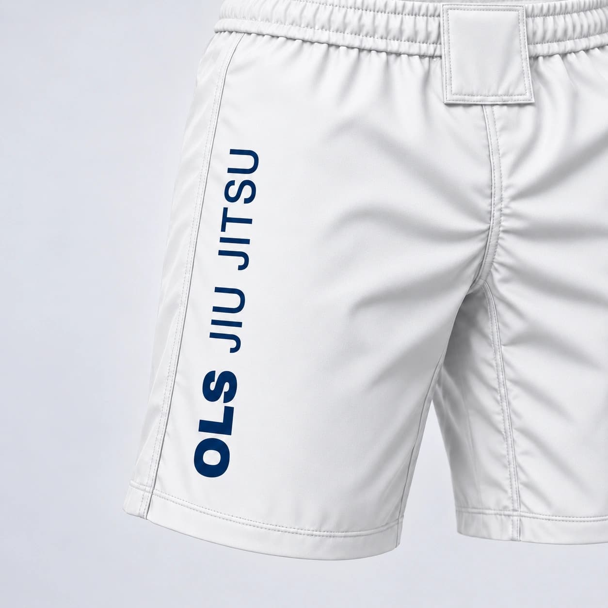 O cós e a assinatura OLS JIU JITSU na lateral da Bermuda OLS branca