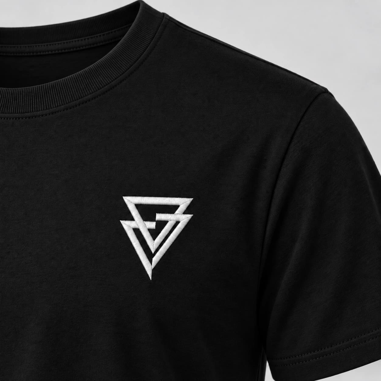 A gola, o ombro e o símbolo bordado no peito da Camiseta OLS preta